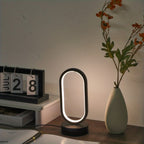 Mini Lámpara de Mesa LED USB Regulable 3 Colores encendida sobre un escritorio de madera