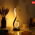 Lámpara de Escritorio LED de Hierro Minimalista encendida sobre un escritorio de madera