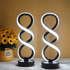 Juego 2 Lámparas de Escritorio LED Espiral encendida sobre un escritorio de madera