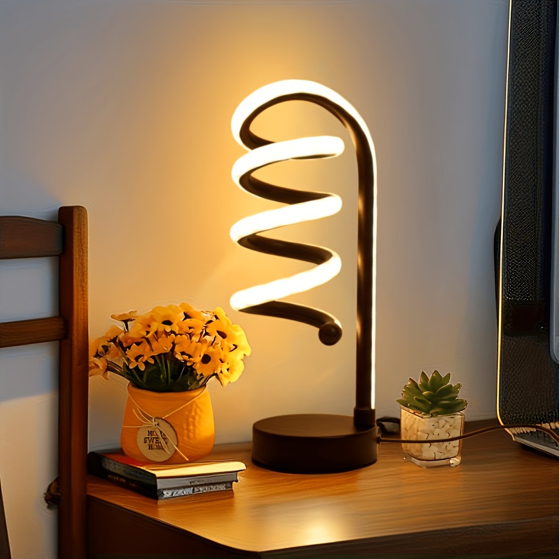 Lámpara de Escritorio LED Espiral Curva Luz Cálida encendida sobre un escritorio de madera
