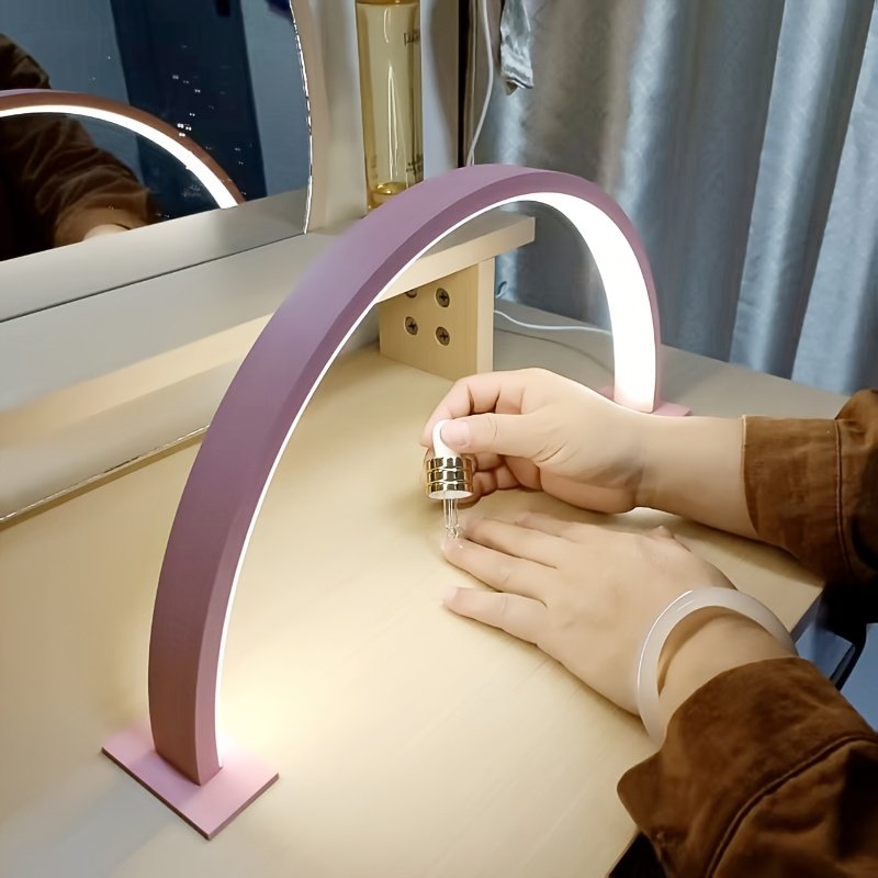 Lámpara de Escritorio LED Luna Brazo Flexible encendida sobre un escritorio de madera