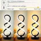 Lámpara de Escritorio LED Concha Espiral USB apagada sobre un buró junto a la cama