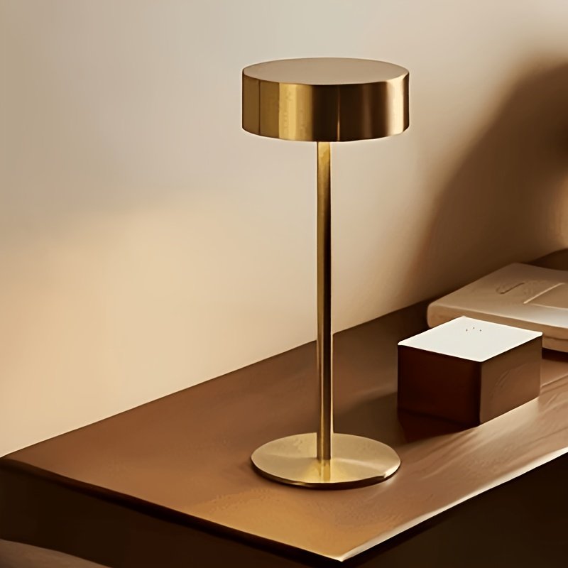 Lámpara de Escritorio LED Recargable Táctil Metal encendida sobre un escritorio de madera