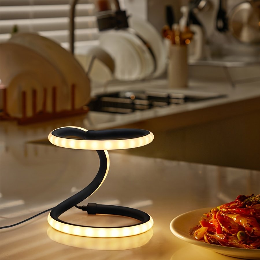 Lámpara de Mesa LED Doble Anillo Infinito Dorada apagada sobre un buró junto a la cama