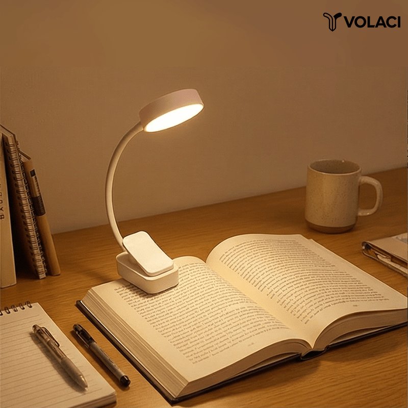 Lámpara de Lectura LED con Clip Portátil VOLACI encendida sobre un escritorio de madera